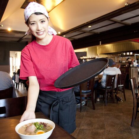 ラーメンを配膳するスタッフ